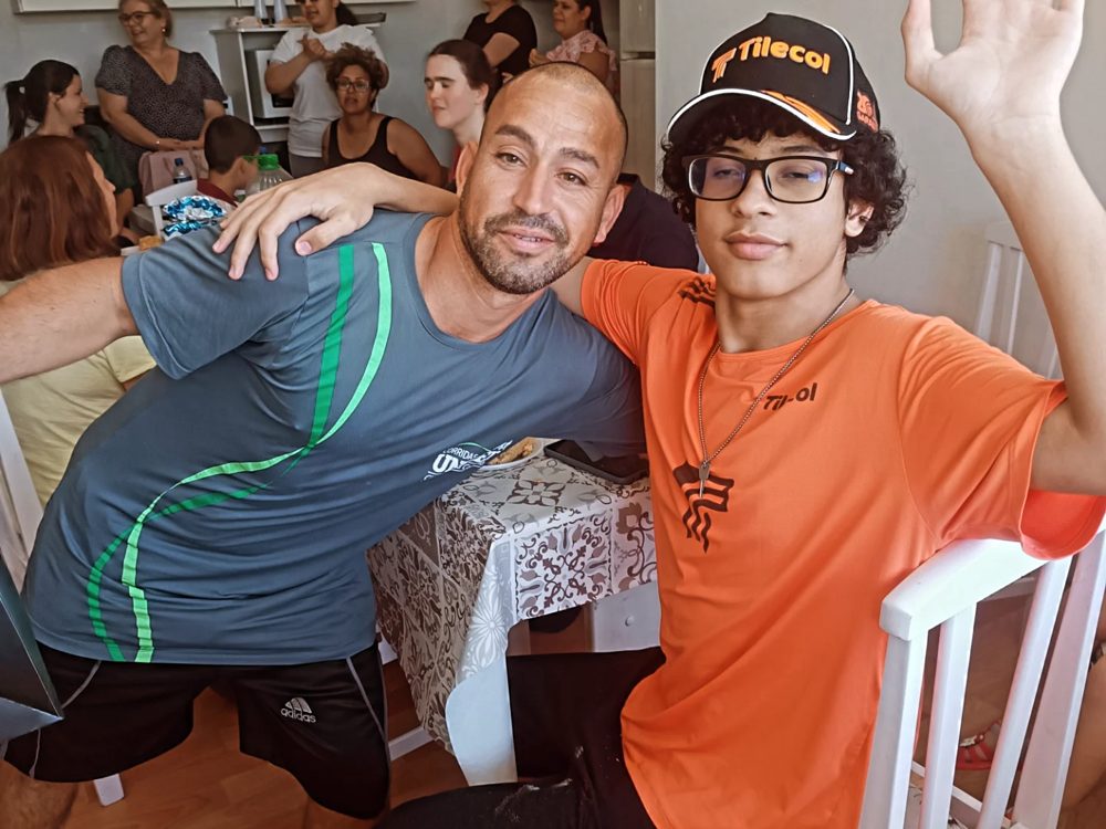 Dois alunos sorrindo e brincando durante a confraternização de fim de ano