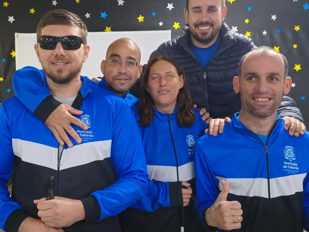 Os cinco atletas da ATIDEV, de agasalho azul, reunidos e sorrindo no Parajasc 2026