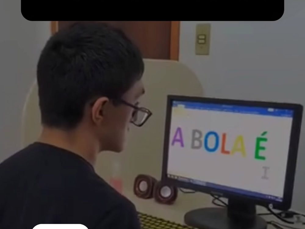 Aluno de óculos usando o computador na sala de informática do CEERPC