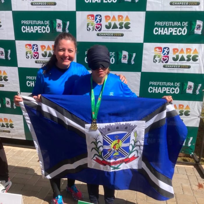 Sandra com a medalha de bronze dos 200 m rasos e a bandeira de Tubarão no Parajasc 2026
